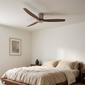 Bozeman ceiling fan in walnut and brushed silver above a bed
