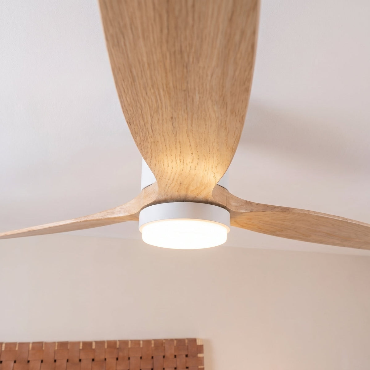 The opal light diffuser seen from below, between the oak blades